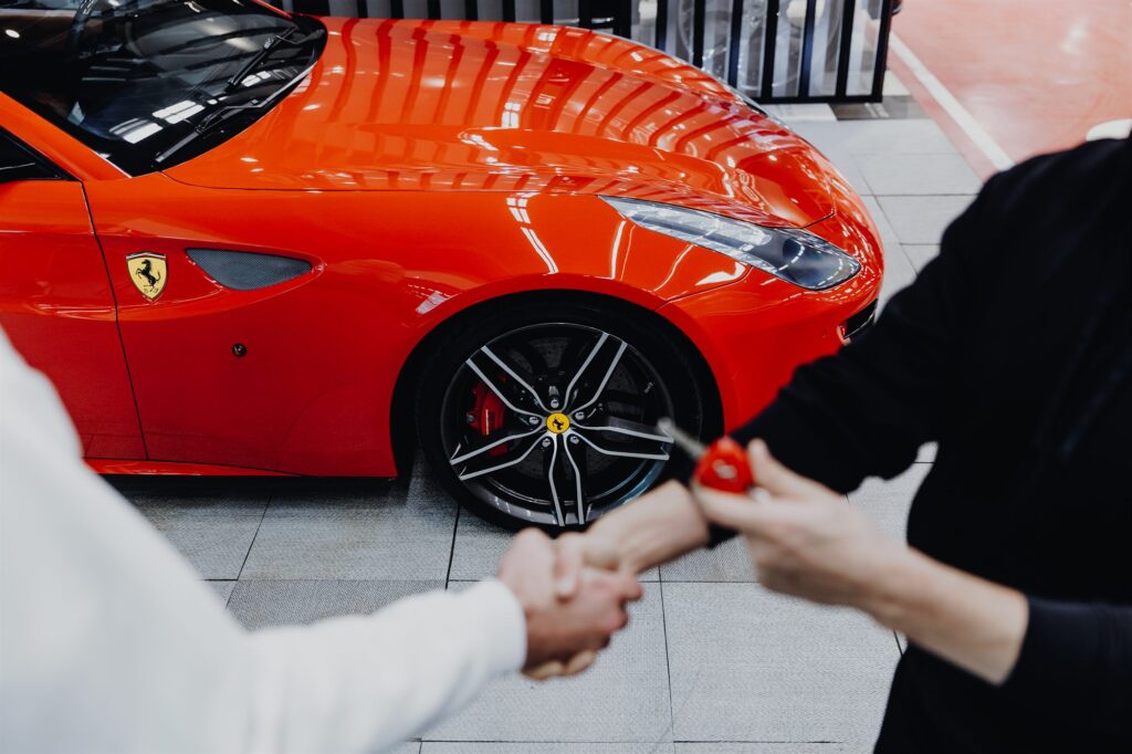 Atslēgu nodošana pircējam pie sarkana Ferrari STUTTGART WORKSHOP salonā
